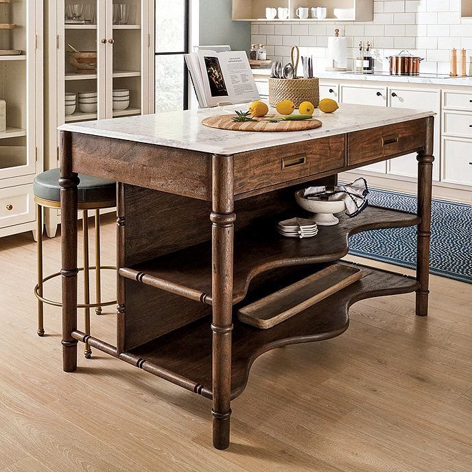 Dark wood kitchen island with a white marble top and open shelving.