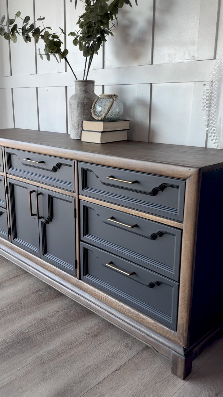 Grey-blue sideboard with a reclaimed wood top and gold hardware against white paneling