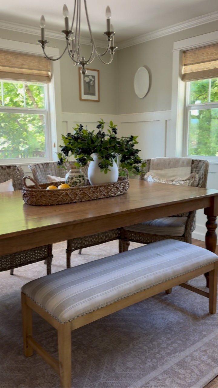 Wooden dining bench with striped upholstery paired with a large wooden dining table.