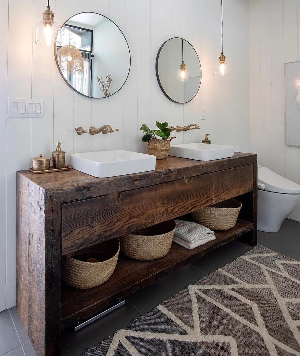 Rustic reclaimed wood bathroom vanity with white vessel sinks and woven storage baskets.