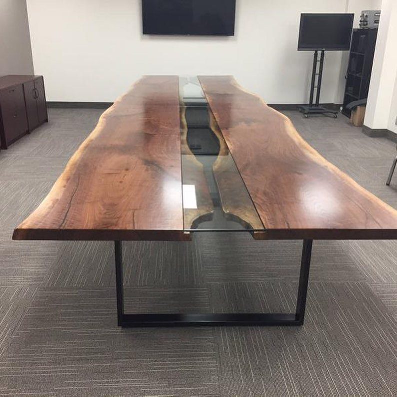 Live-edge wooden river table with black metal legs in a modern office setting.