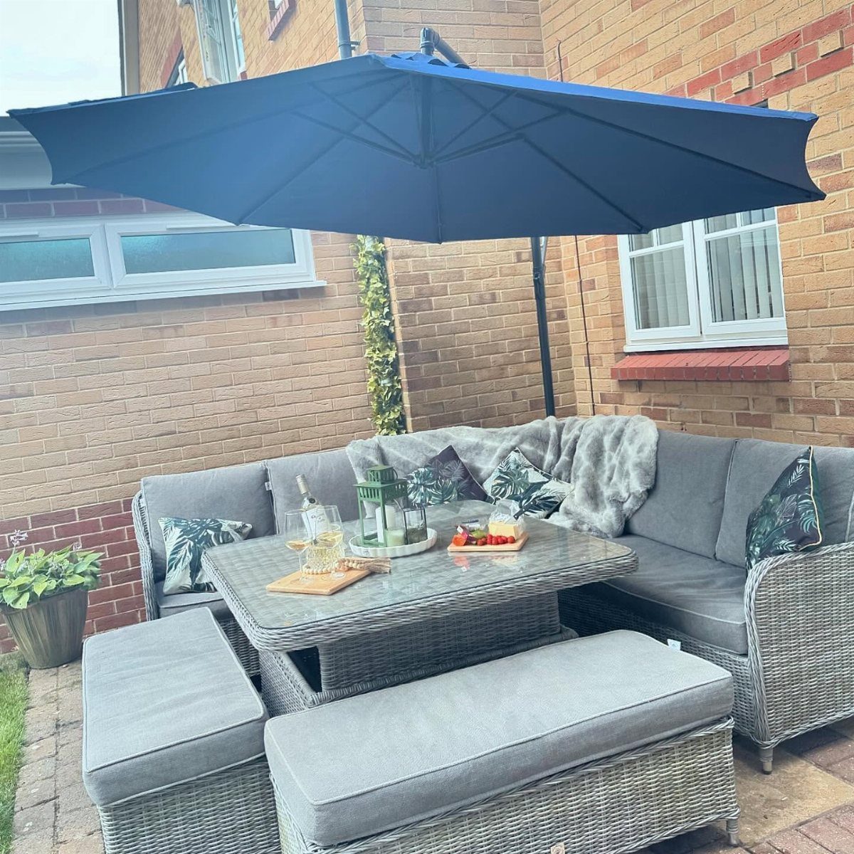 29 Scandinavian Outdoor Furniture for Patios and Gardens 13 Navy blue cantilever parasol shading a grey rattan outdoor lounge furniture set.
