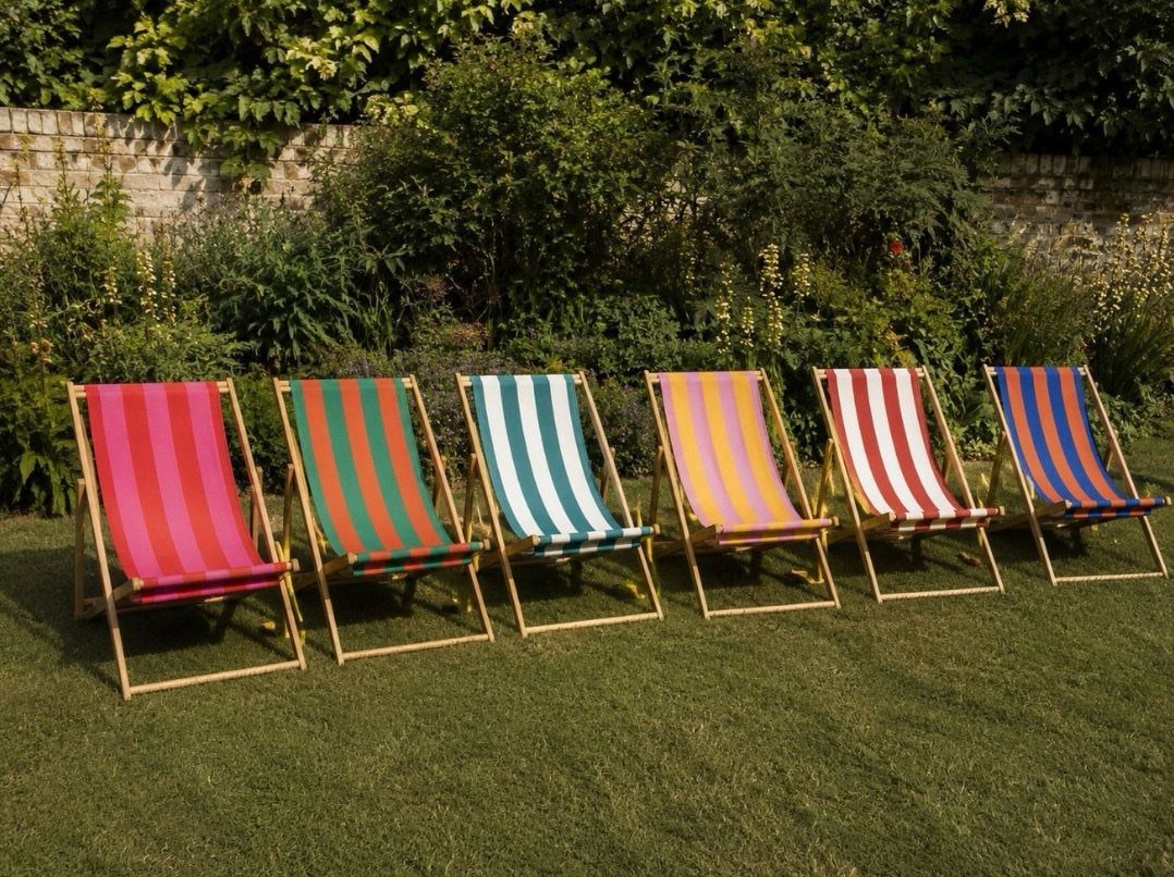 29 Scandinavian Outdoor Furniture for Patios and Gardens 9 Six colorful striped folding deck chairs lined up on a green garden lawn.