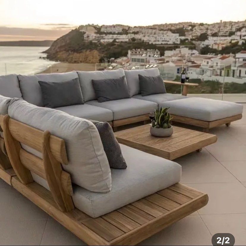 29 Scandinavian Outdoor Furniture for Patios and Gardens 11 Light grey modular outdoor sofa with wooden frames on a coastal terrace.