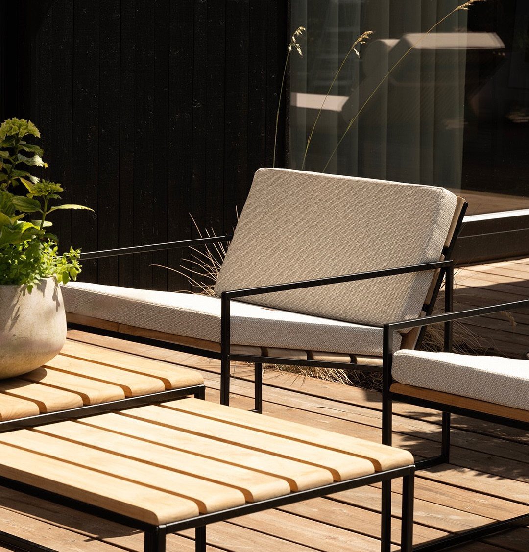29 Scandinavian Outdoor Furniture for Patios and Gardens 4 Modern outdoor lounge with grey cushioned sofa and slatted wooden coffee tables.