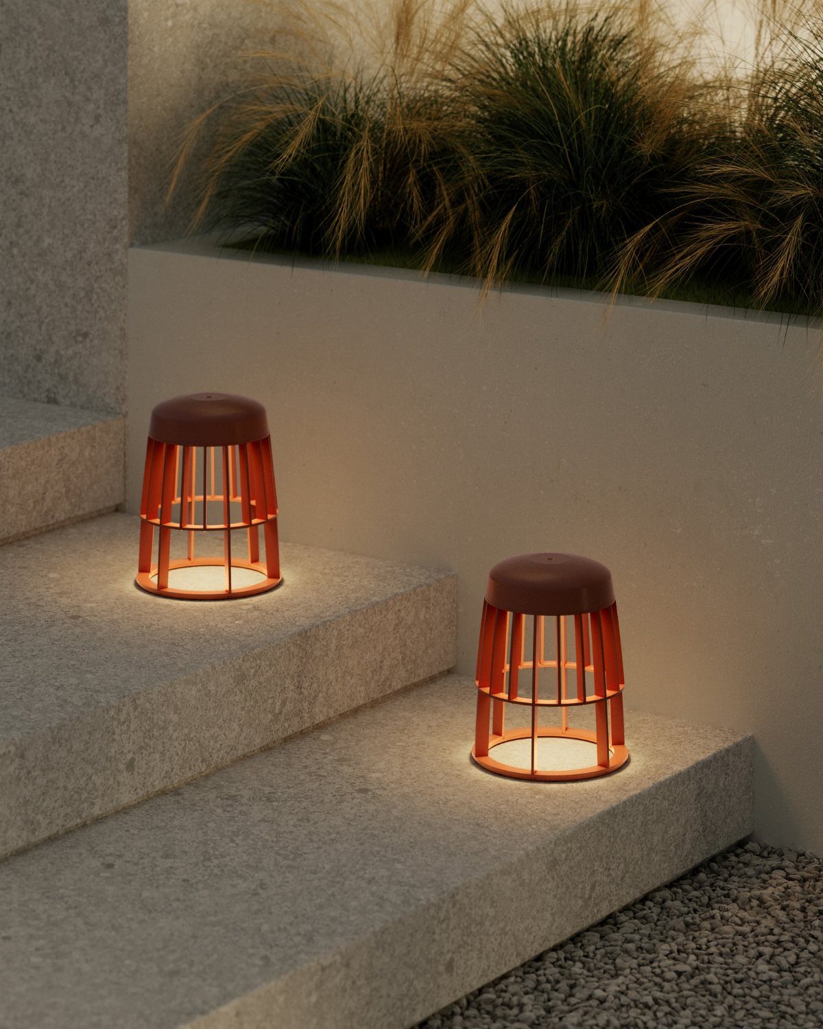 29 Scandinavian Outdoor Furniture for Patios and Gardens 14 Two orange-brown slatted lanterns emitting warm light on grey stone outdoor steps.