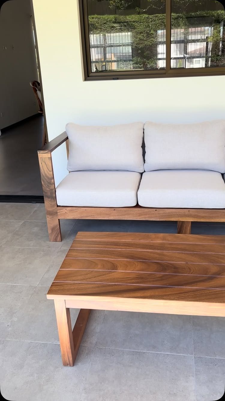 29 Scandinavian Outdoor Furniture for Patios and Gardens 23 Wooden outdoor sofa with white cushions and a matching wooden coffee table.