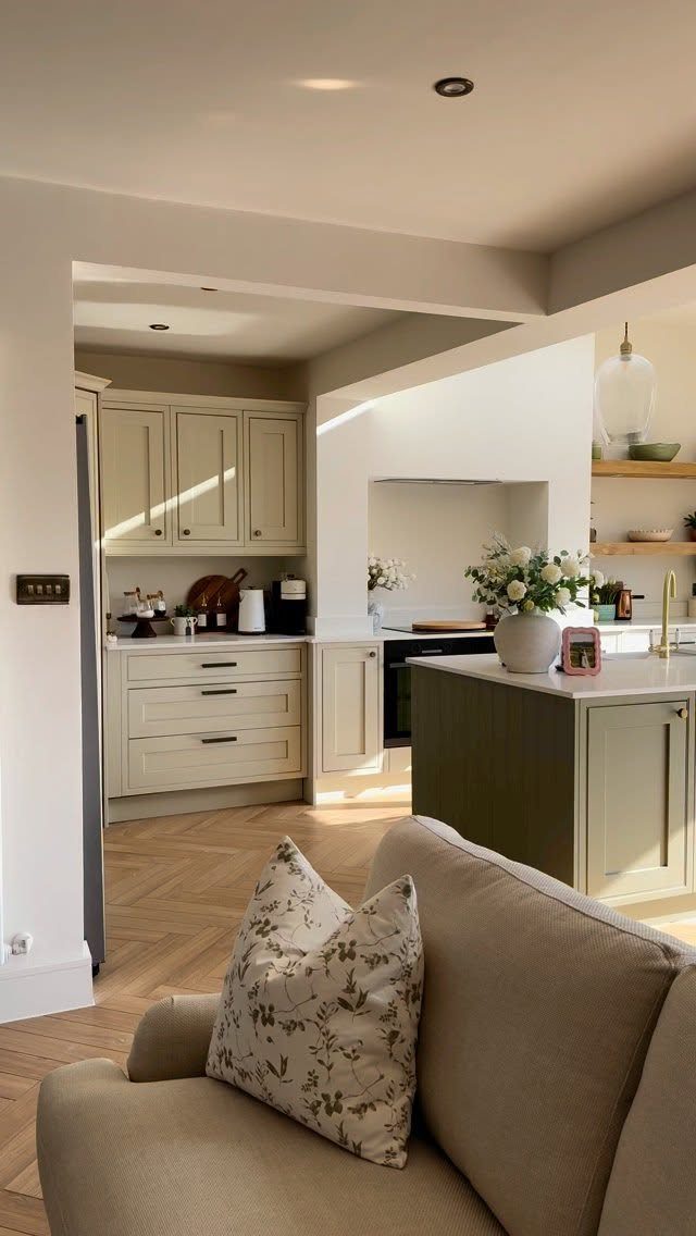 Small kitchen with cream cabinets, a green peninsula, and wooden open wall shelving.