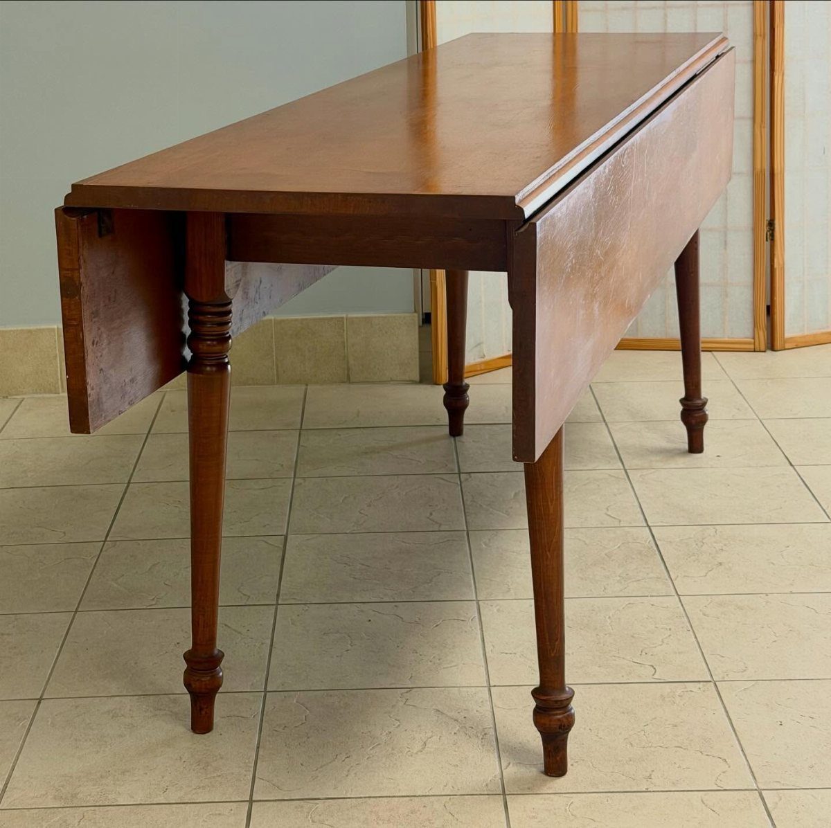 Solid Wood Dining Table Set: 20 Ideas for Your Home 17 Rectangular reddish-brown solid wood dining table with drop-leaf sides and turned legs.