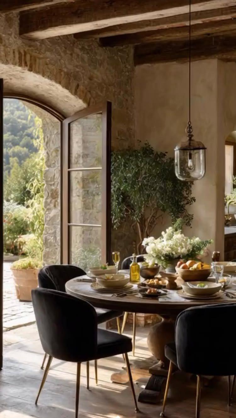 Solid Wood Dining Table Set: 20 Ideas for Your Home 4 Round wooden dining table with black velvet chairs in a rustic stone room.