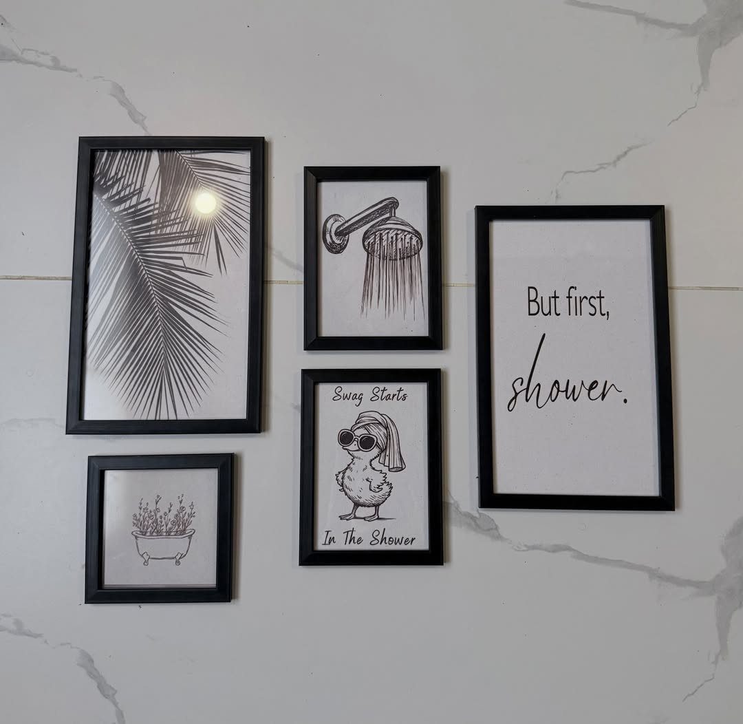 19 Teen Bathroom Ideas That Blend Style and Function 5 Five black-framed bathroom art prints hanging on a white marble wall.