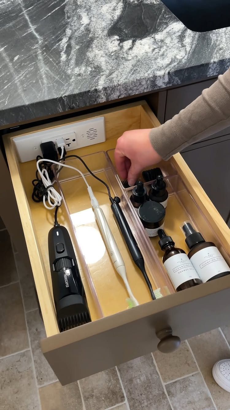 19 Teen Bathroom Ideas That Blend Style and Function 16 Open bathroom drawer containing hair tools and skincare bottles with an integrated power outlet.