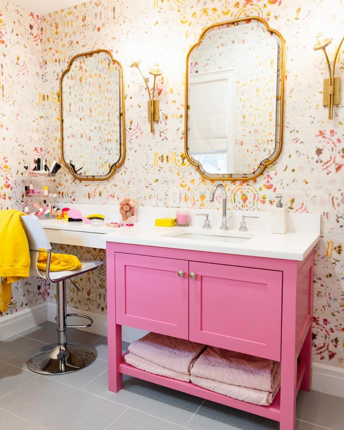 19 Teen Bathroom Ideas That Blend Style and Function 11 Bright pink bathroom vanity with white countertop and gold mirrors against patterned wallpaper.