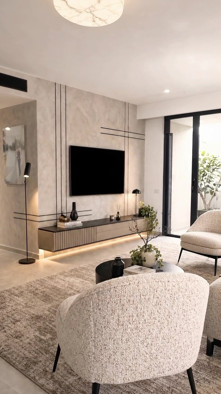 Modern living room with a concrete textured wall backdrop and wall-mounted television.