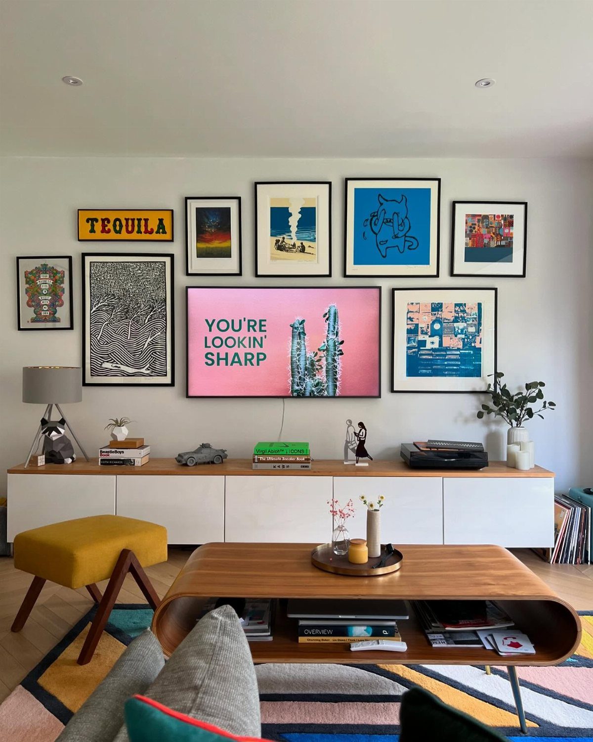 TV surrounded by a gallery wall of framed art in a modern living room