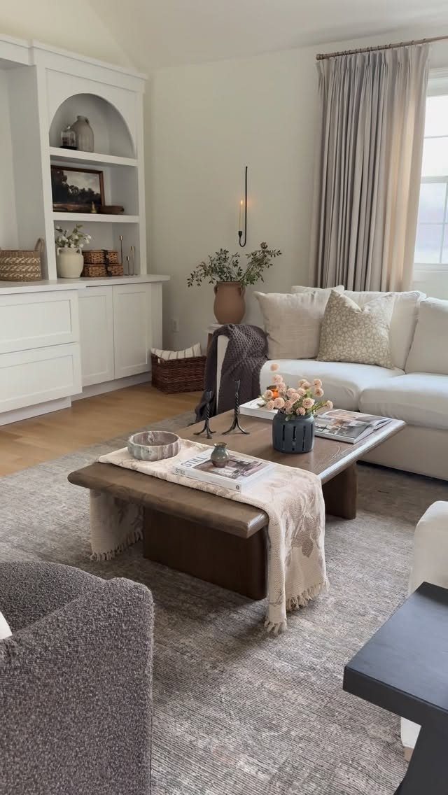 Wooden coffee table with a small bowl, books, and a white throw blanket.